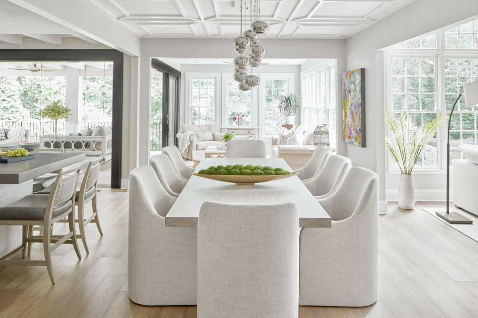 bright open concept home with white dining table and chairs opening into sitting area and kitchen